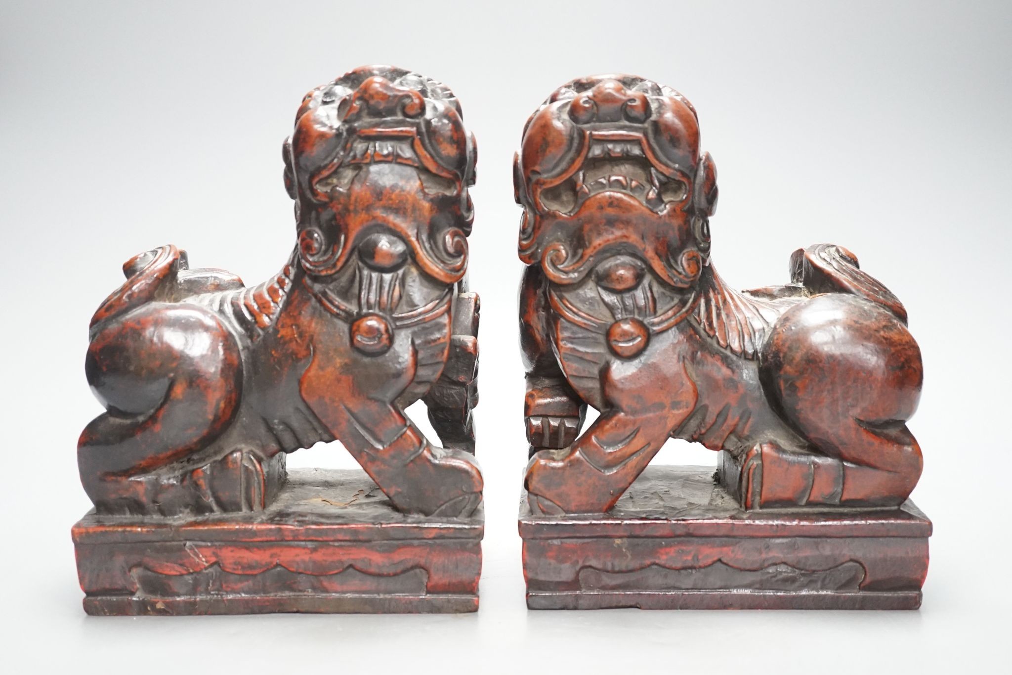 A pair of Japanese carved and red lacquered wood models of temple dogs, Edo period, 21.5 cms high.